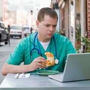 Physician at laptop in sidwalk cafe