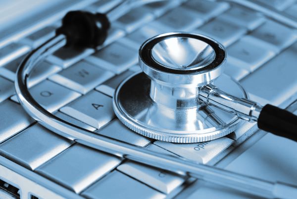 Silver stethoscope over laptop 600x400