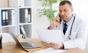 Male doctor on the phone in his office.