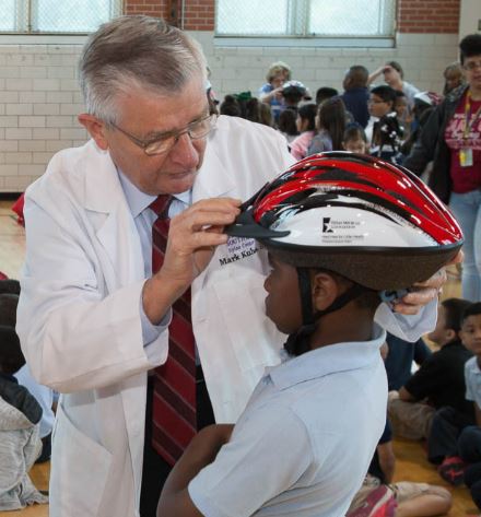 Dr. Kubala fits a helmet on a child during a Hard Hats for Little Heads event. Dr. Kubala fits a helmet on a child during a Hard Hats for Little Heads event.